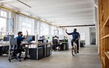 Man riding bicycle in office - seems popular