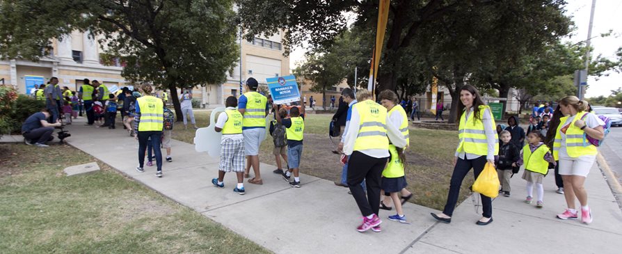 Adluts and kids walking together for Walk to School Day